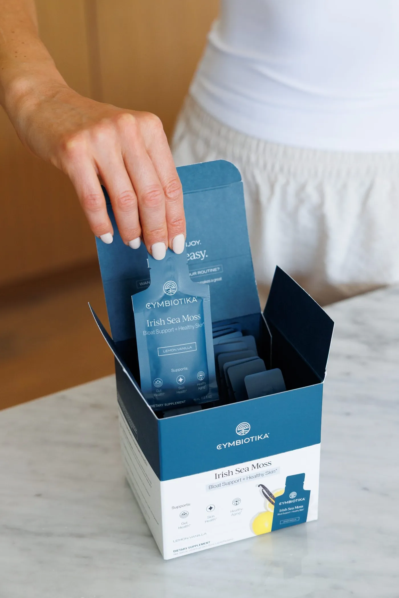 Hand pulling a packet from the Irish Sea Moss box